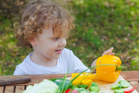 little boy and vegetables on the tableの写真素材
