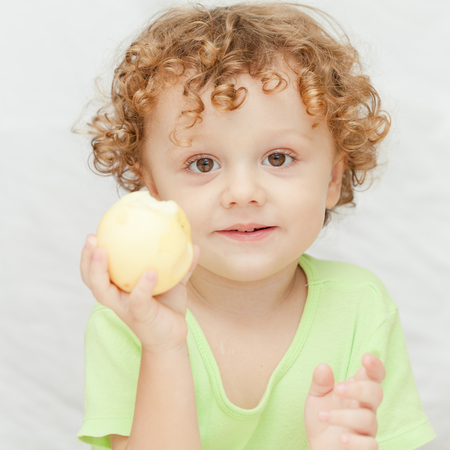 little boy holding appleの写真素材