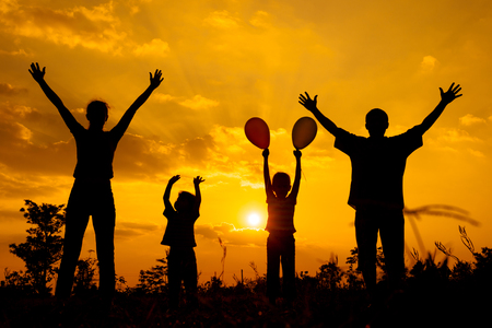 Happy  family playing with balloons on the  road in the  sunset time  Evening party on the natureの写真素材