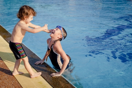 one little girl and little boy playing in the swimming poolの写真素材