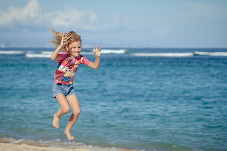 flying jumping beach girl at blue sea shore in summer vacation in the day timeの写真素材