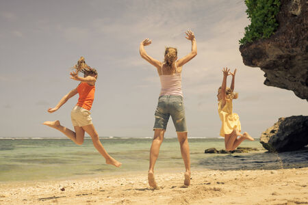 Happy family playing on the beach at the day timeの写真素材