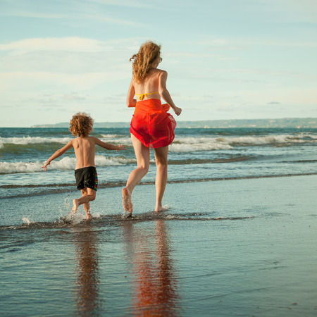 mother and  son playing on the beach in the day timeの写真素材