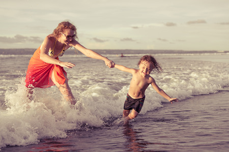 mother and  son playing on the beach in the day timeの写真素材