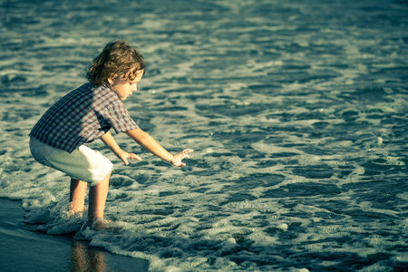 little boy playing on the beach at the day timeの写真素材