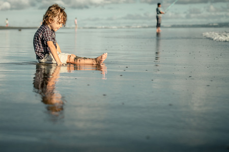 little boy playing on the beach at the day timeの写真素材