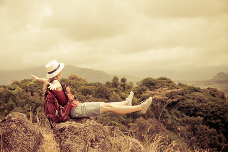 tourist with backpack relaxing on rock and enjoying admiring the view の写真素材