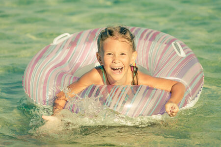 Happy little girl playing on the sea