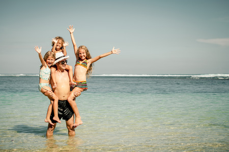 Happy family playing on the beach at the day timeの写真素材