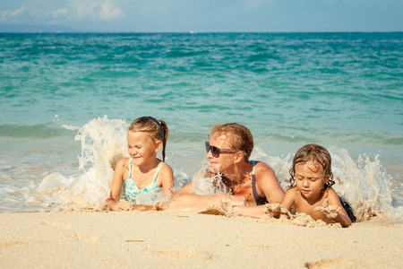 Happy family lying on the beach at the day timeの写真素材