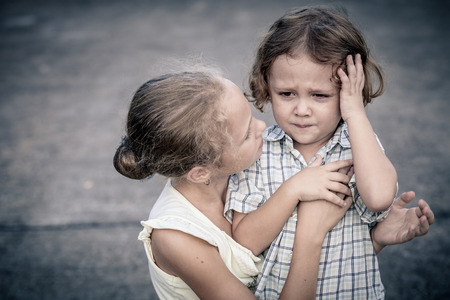 Portrait of sad teen girl and little boy at the day time