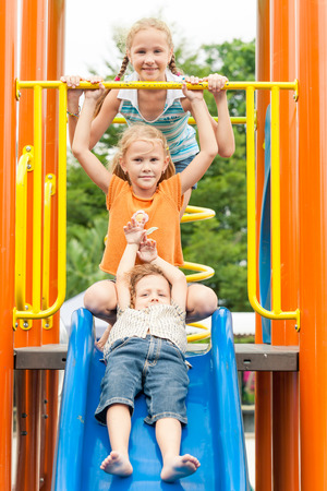 Three happy children on the playground at the day timeの写真素材