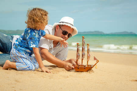 Father and son playing on the beach at the day time. Concept of friendly family.の写真素材