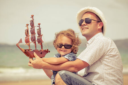 Father and son playing on the beach at the day time. Concept of friendly family.の写真素材