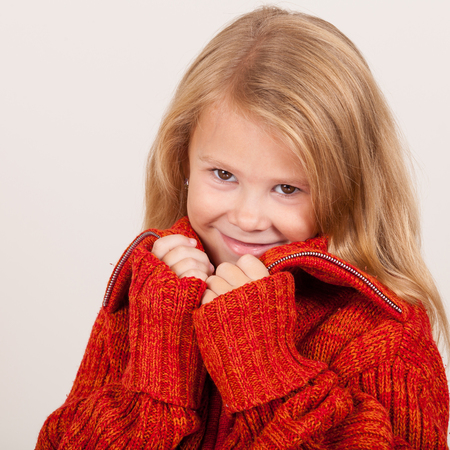 portrait of a cute little girl in red sweaterの写真素材