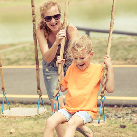 Happy family playing on the playground at the day timeの写真素材