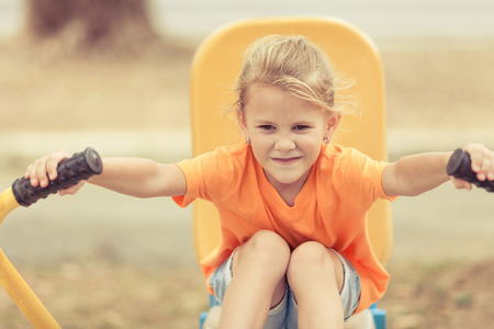 Happy little girl on the playground at the day timeの写真素材
