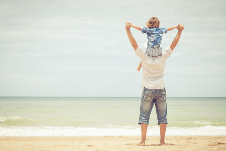 Father and son playing on the beach at the day time. Concept of friendly family.の写真素材