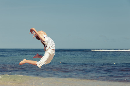 teen girl  jumping on the beach at blue sea shore in summer vacation at the day time