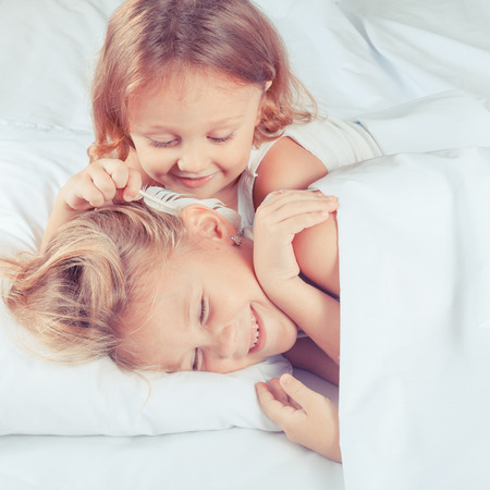 Lovely brother and sister lying in bed at home. Concept of Brother And Sister Together Foreverの写真素材