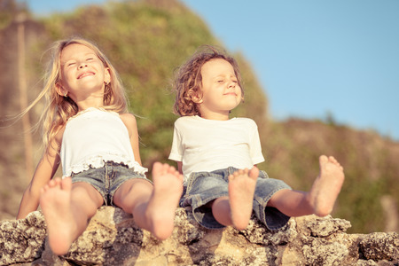 Two happy children  playing on the beach at the day timeの写真素材