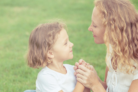Mother and son playing on the grass at the day time. Concept of friendly family.の写真素材