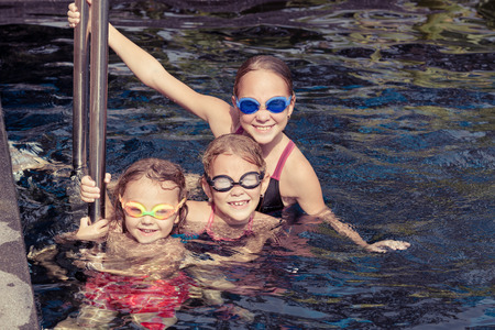 happy children  playing on the swimming pool at the day timeの写真素材