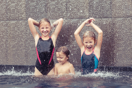 happy children  playing on the swimming pool at the day timeの写真素材