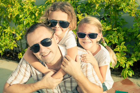 Dad and children playing near a house at the day time. Concept of friendly family.の写真素材