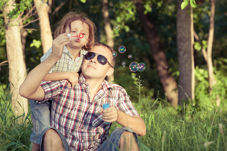Father and son playing at the park at the day time. Concept of friendly family.の写真素材