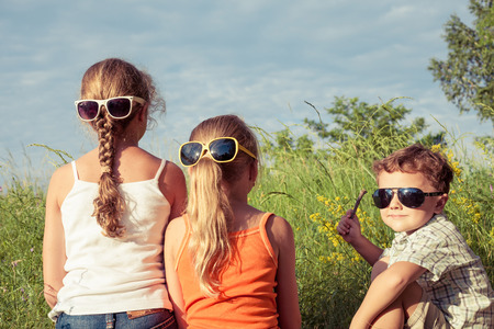 Three happy children  playing near the tree at the day time. Concept Brother And Sister Together Foreverの写真素材