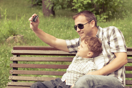 Father and son playing at the park at the day time. Concept of friendly family.の写真素材