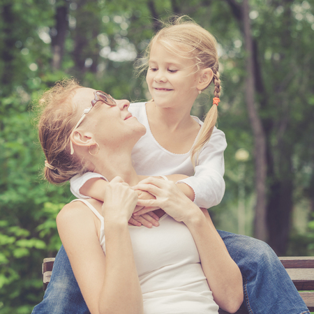 Mother and daughter playing at the park at the day time. Concept of friendly family.の写真素材