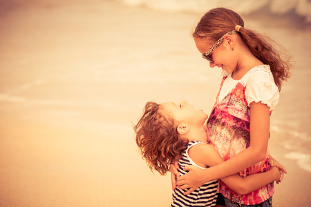 Sister and brother playing on the beach at the day time. Concept Brother And Sister Together Foreverの写真素材