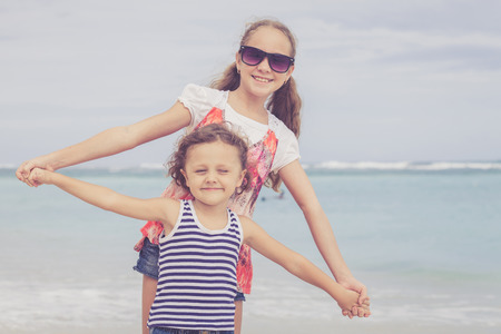 Sister and brother playing on the beach at the day time. Concept Brother And Sister Together Foreverの写真素材