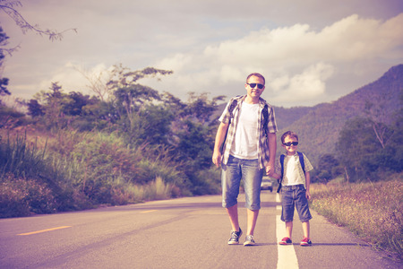 Father and son walking on the road at the day time.  Concept of friendly family.の写真素材