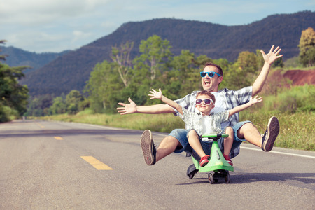 Father and son playing  on the road at the day time.  Concept of friendly family.の写真素材