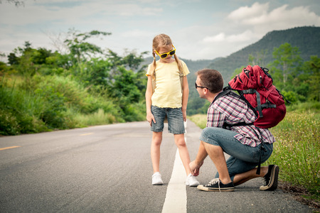Father and daughter walking on the road at the day time.  Concept of friendly family.の写真素材
