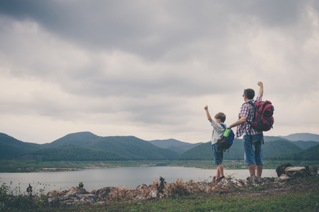 Father and son standing near the lake at the day time.  Concept of friendly family.の写真素材