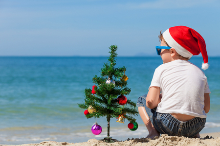 Happy little boy sitting on the beach at the day time. Concept of Happy New Year.の写真素材