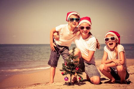 Three happy children  playing on the beach at the day time. Concept of Happy New Year.の写真素材