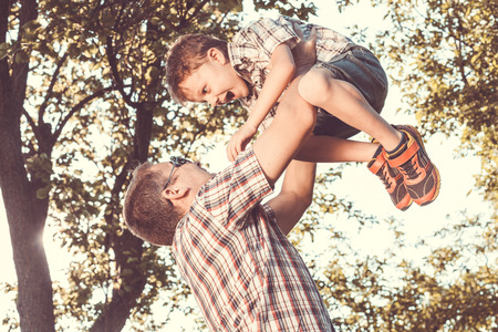 Father and son playing at the park at the day time. People having fun outdoors. Concept of friendly family.の写真素材