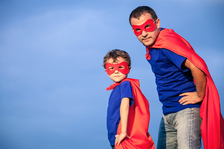 Father and son playing superhero at the day time. People having fun outdoors. Concept of friendly family.の写真素材