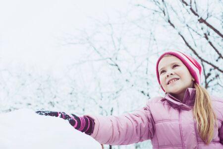 Happy little girl playing  on winter snow day. Concept of life.