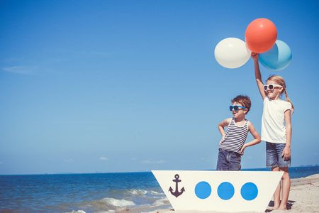 Happy children playing on the beach at the day time. Concept of happy friendly family.の写真素材