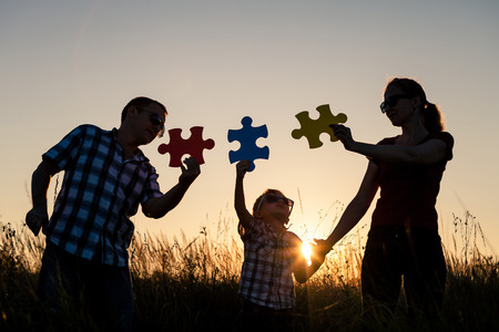 Happy family playing at the park at the sunset time. People having fun on the field. Concept of the kid is ready to go to school.の写真素材