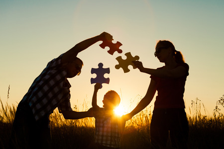 Happy family playing at the park at the sunset time. People having fun on the field. Concept of the kid is ready to go to school.の写真素材