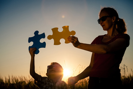Mother and son playing at the park at the sunset time. People having fun on the field. Concept of the kid is ready to go to school.の写真素材