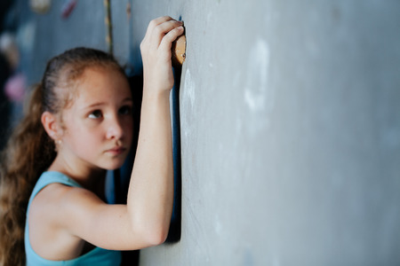 One teenager climbing a rock wall indoor. Concept of sport life.の写真素材
