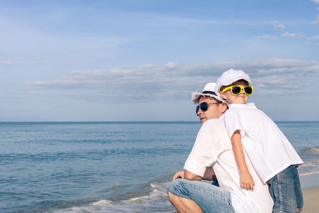 Father and son playing on the beach at the day time. People having fun outdoors. Concept of happy friendly family.の写真素材